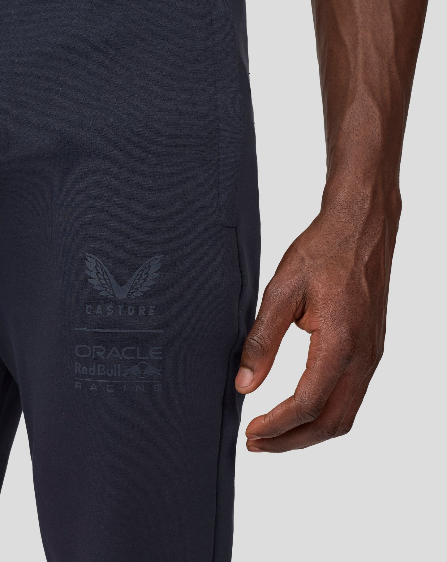 Side view of navy jogger with stitched pocket seam and faint Castore Oracle Red Bull Racing branding.