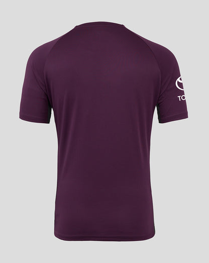 Purple t-shirt with a logo on the sleeve against a gray background