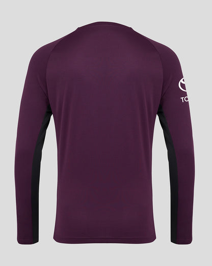 Purple long-sleeve shirt with a logo on the sleeve against a gray background