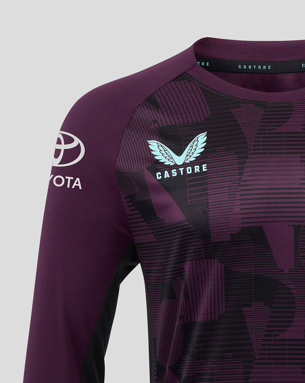Close up of a purple England cricket training jersey showing a light blue winged Castore logo on the chest and a Toyota emblem on the sleeve.