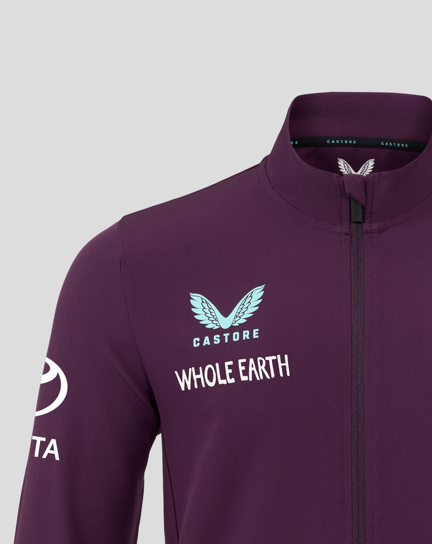 Chest close up of the England 25/26 Anthem Jacket with a light blue crest and Whole Earth text and Castore branding