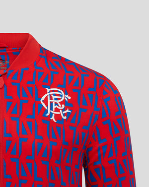 Front close up of Rangers Away Matchday Jacket showing white club crest on red fabric with a blue geometric print and full front zip