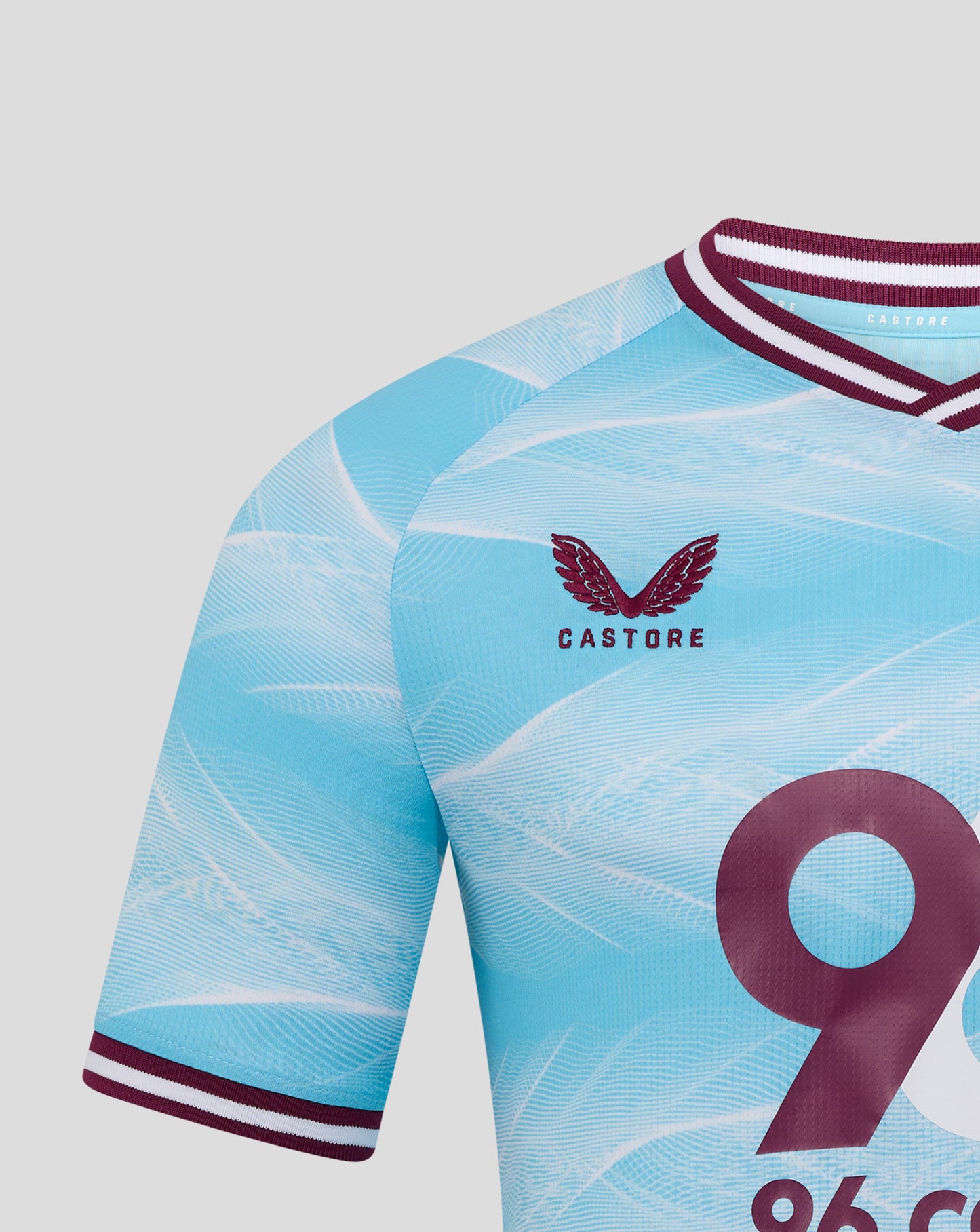 Partial front of Burnley FC away shirt showing a large burgundy number and crest on light blue fabric