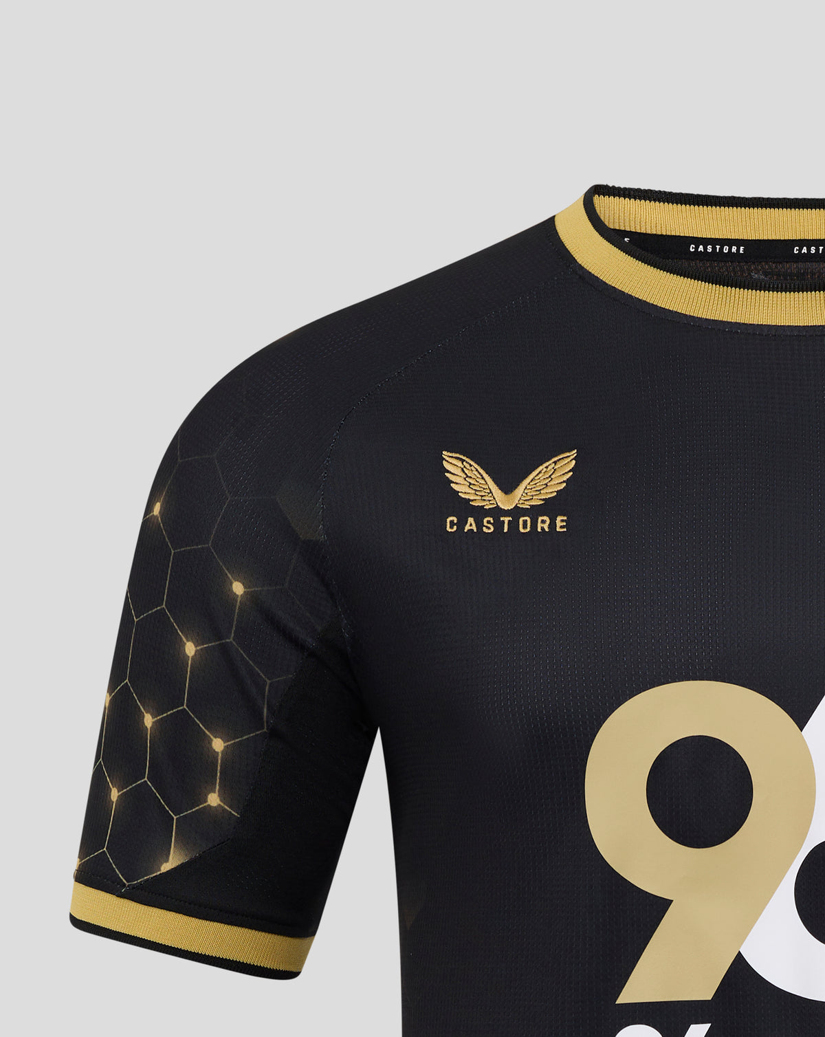 Close up of the navy Burnley FC third shirt showing gold collar trim, honeycomb sleeve pattern, and club crest.