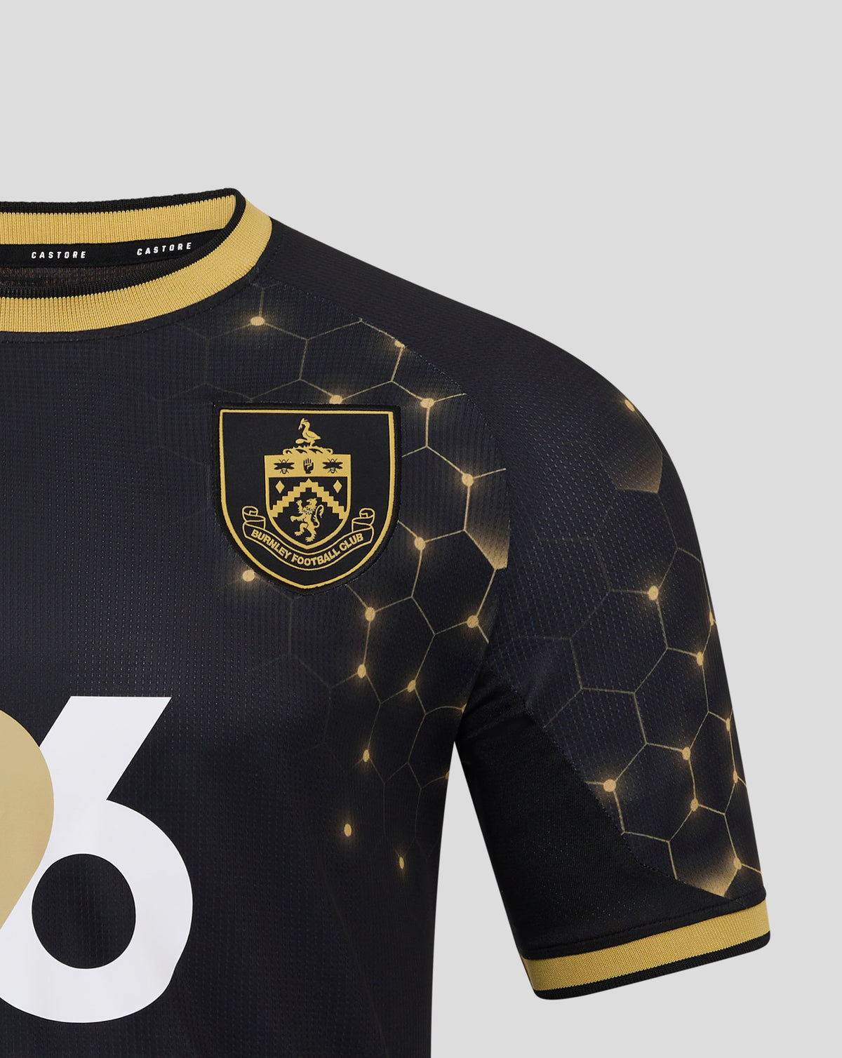Detail of the navy Burnley FC third shirt with crest on the chest, honeycomb pattern, and a large white graphic.