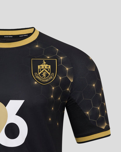 Detail of the navy Burnley FC third shirt with crest on the chest, honeycomb pattern, and a large white graphic.