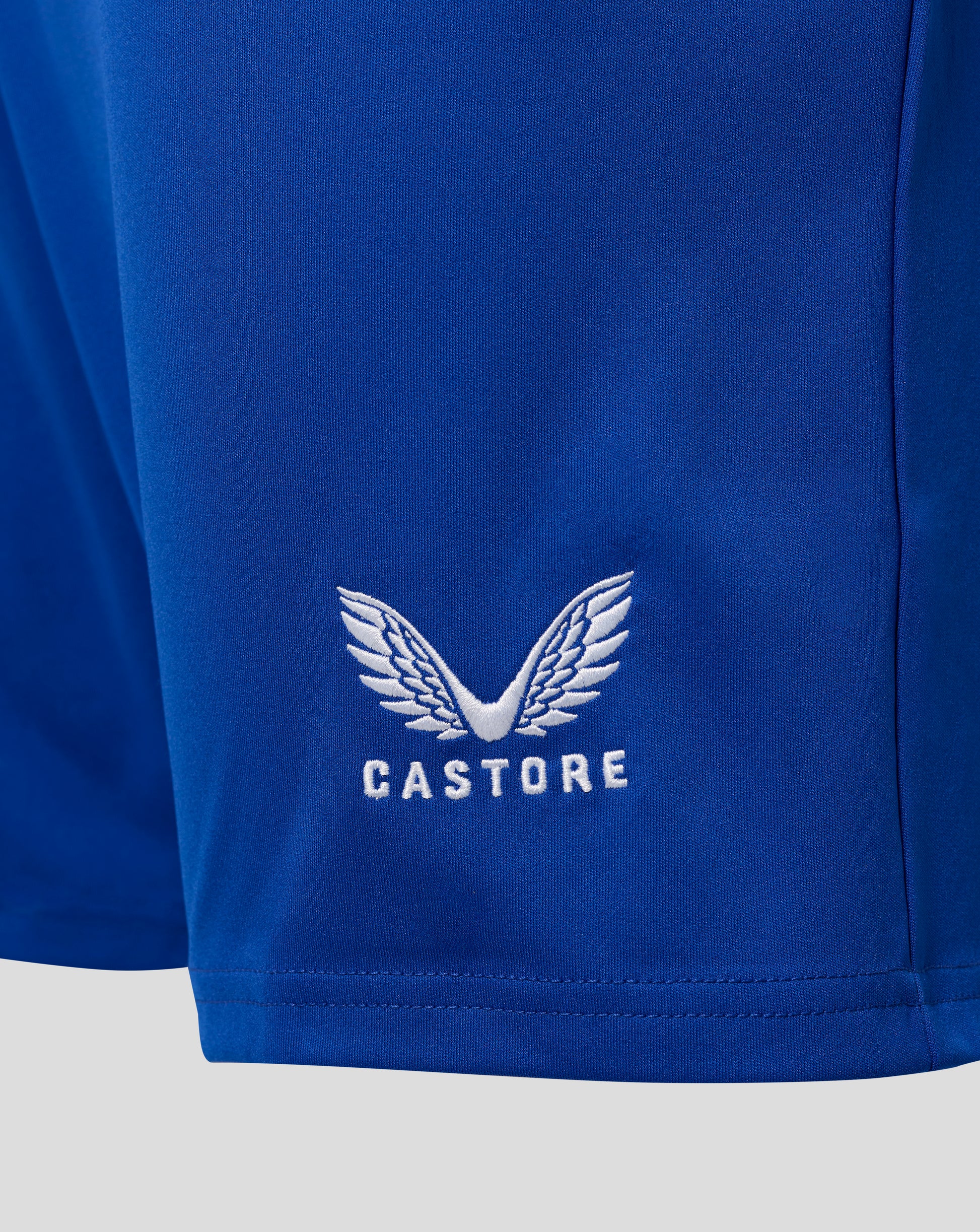 Close-up of blue Everton home shorts fabric showing white Castore crest embroidery