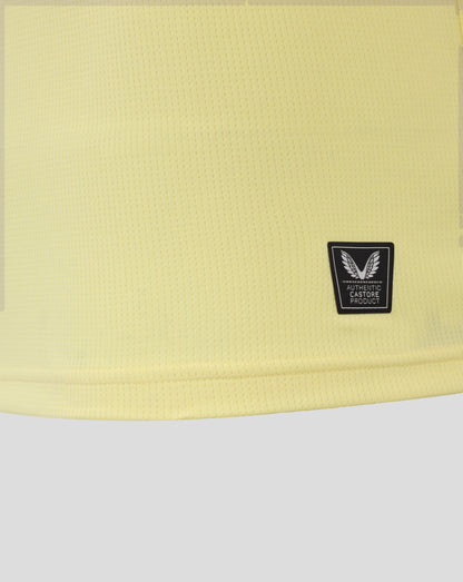 Yellow textured fabric of Everton junior away shirt with a winged crest patch in the lower right corner