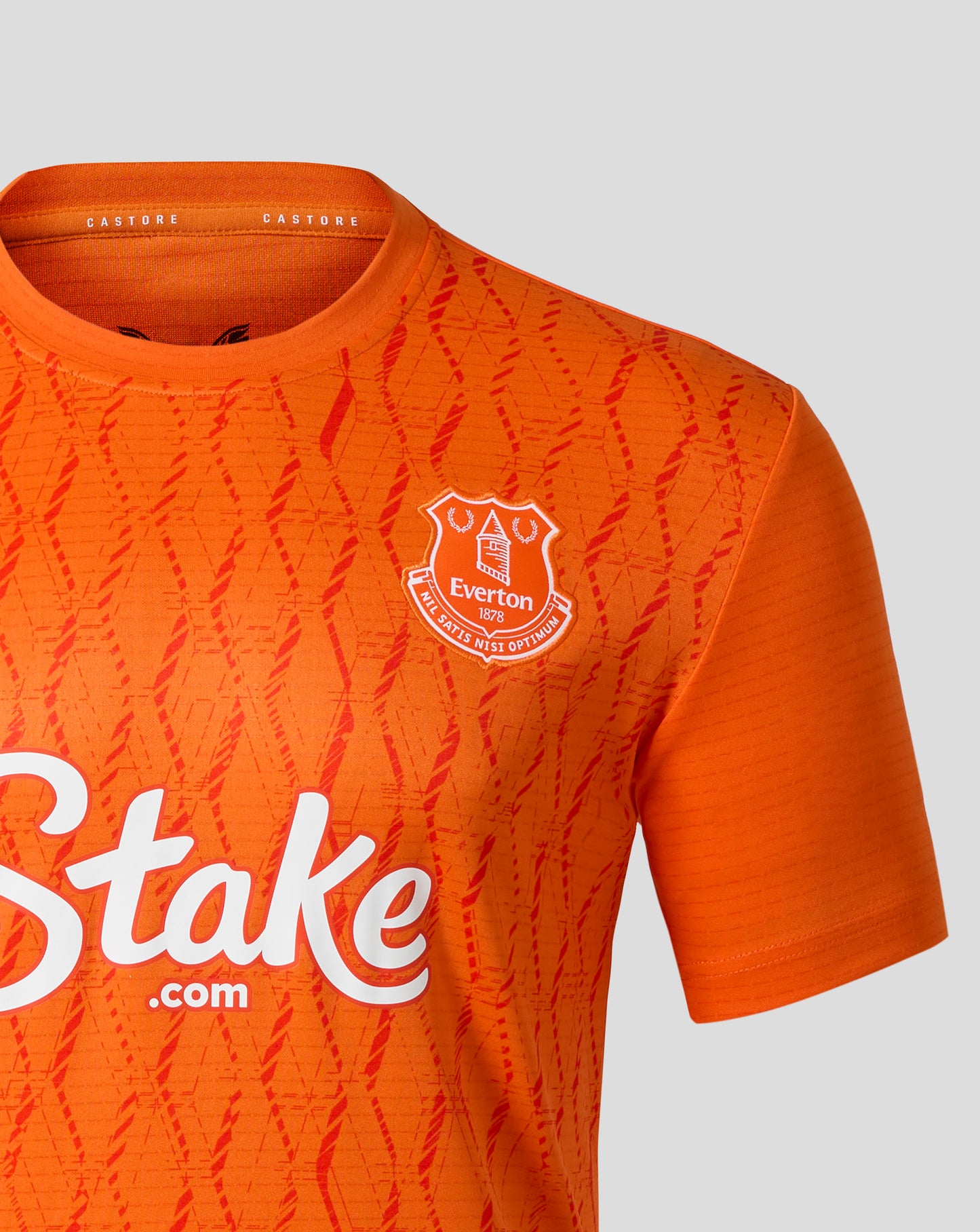 Close up of upper chest on orange Everton third goalkeeper shirt showing club crest and Castore branding