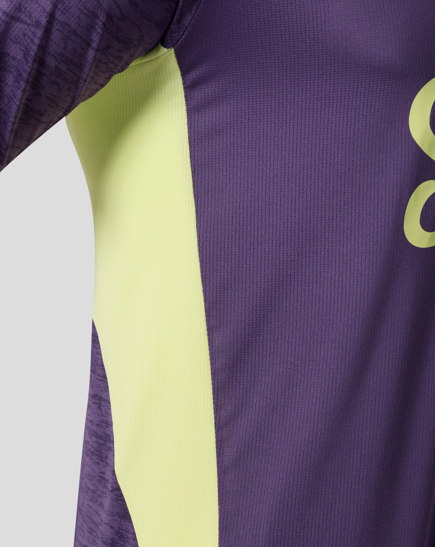 Close up of purple Loganberry Everton training shirt showing lime side panel and textured knit fabric.