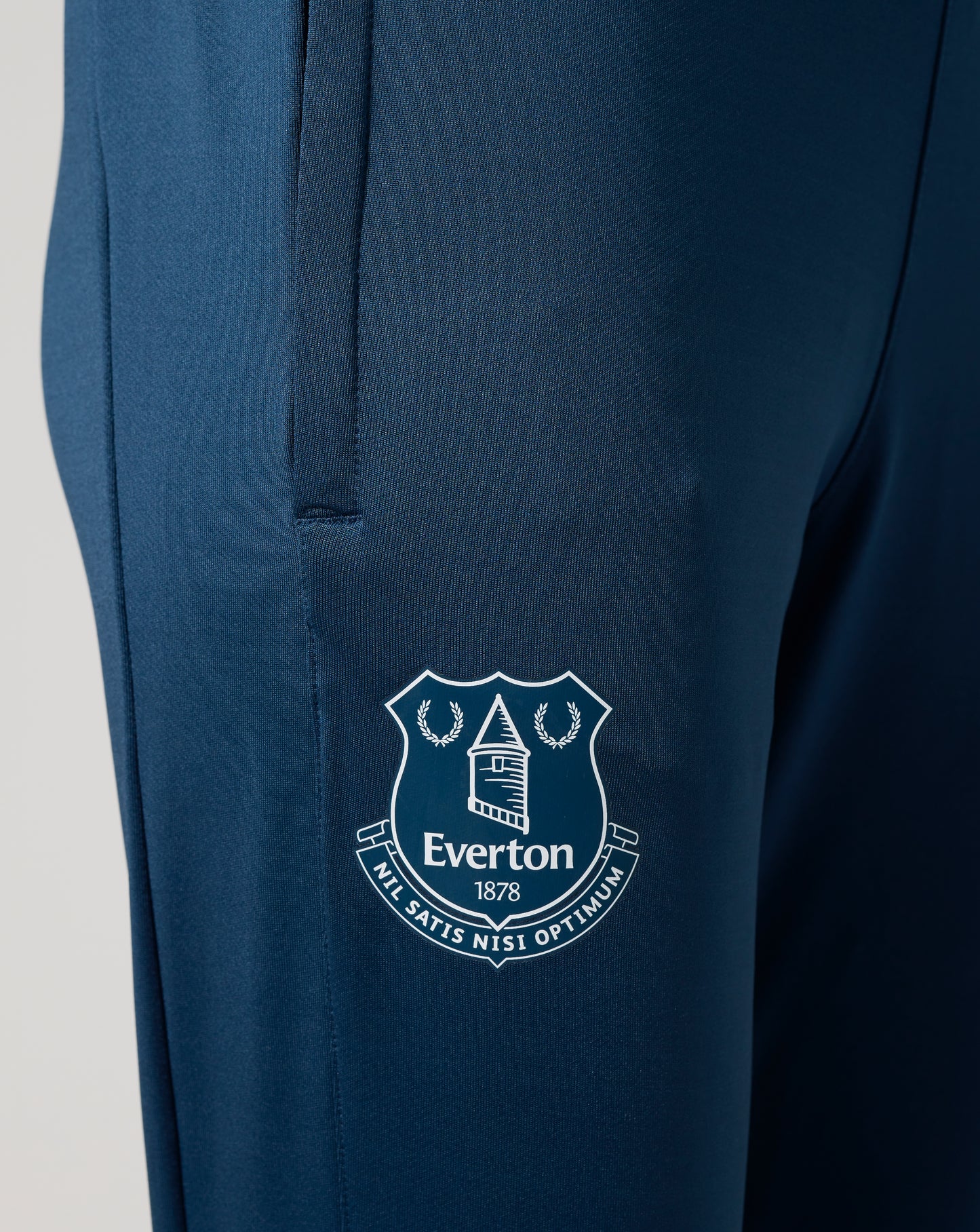 Close up of the blue textured knit fabric with a partial Everton crest emblem visible.