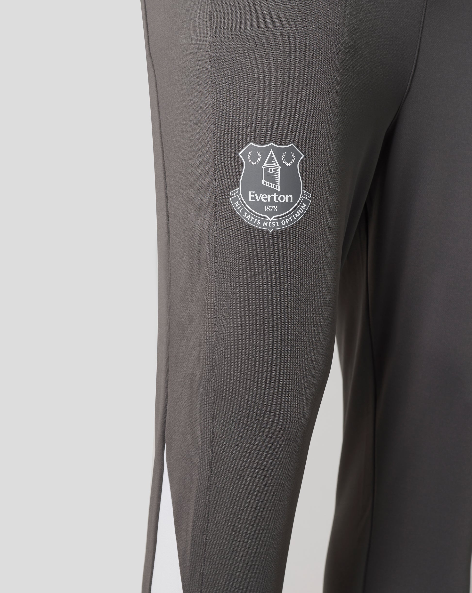 Close-up of dark fabric showing the Everton crest patch on the pant leg.