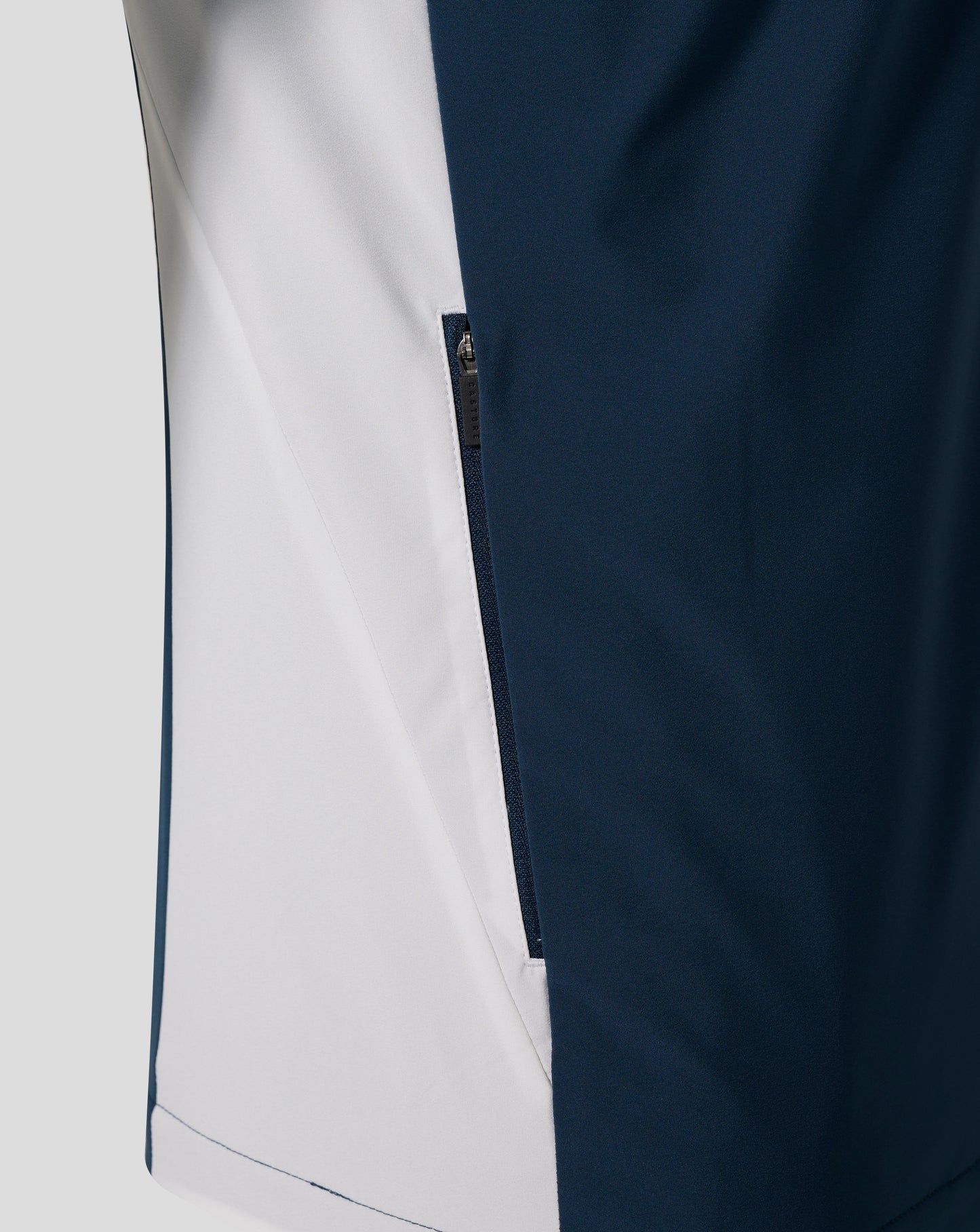 Close-up of Everton Moonlit Ocean packable hooded shower jacket showing navy fabric with a light side panel and a visible zipper.