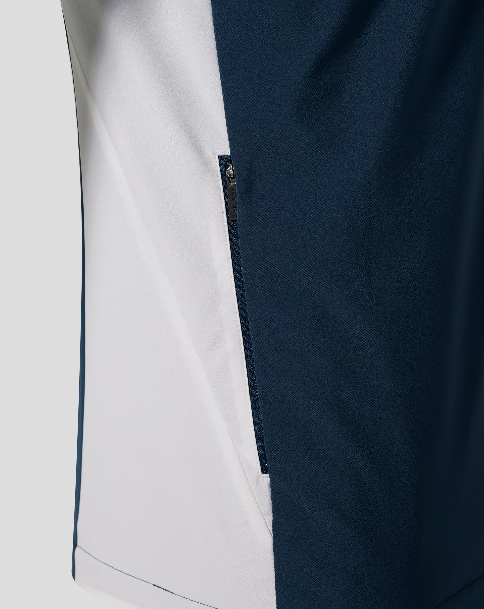 Close-up of Everton Moonlit Ocean packable hooded shower jacket showing navy fabric with a light side panel and a visible zipper.