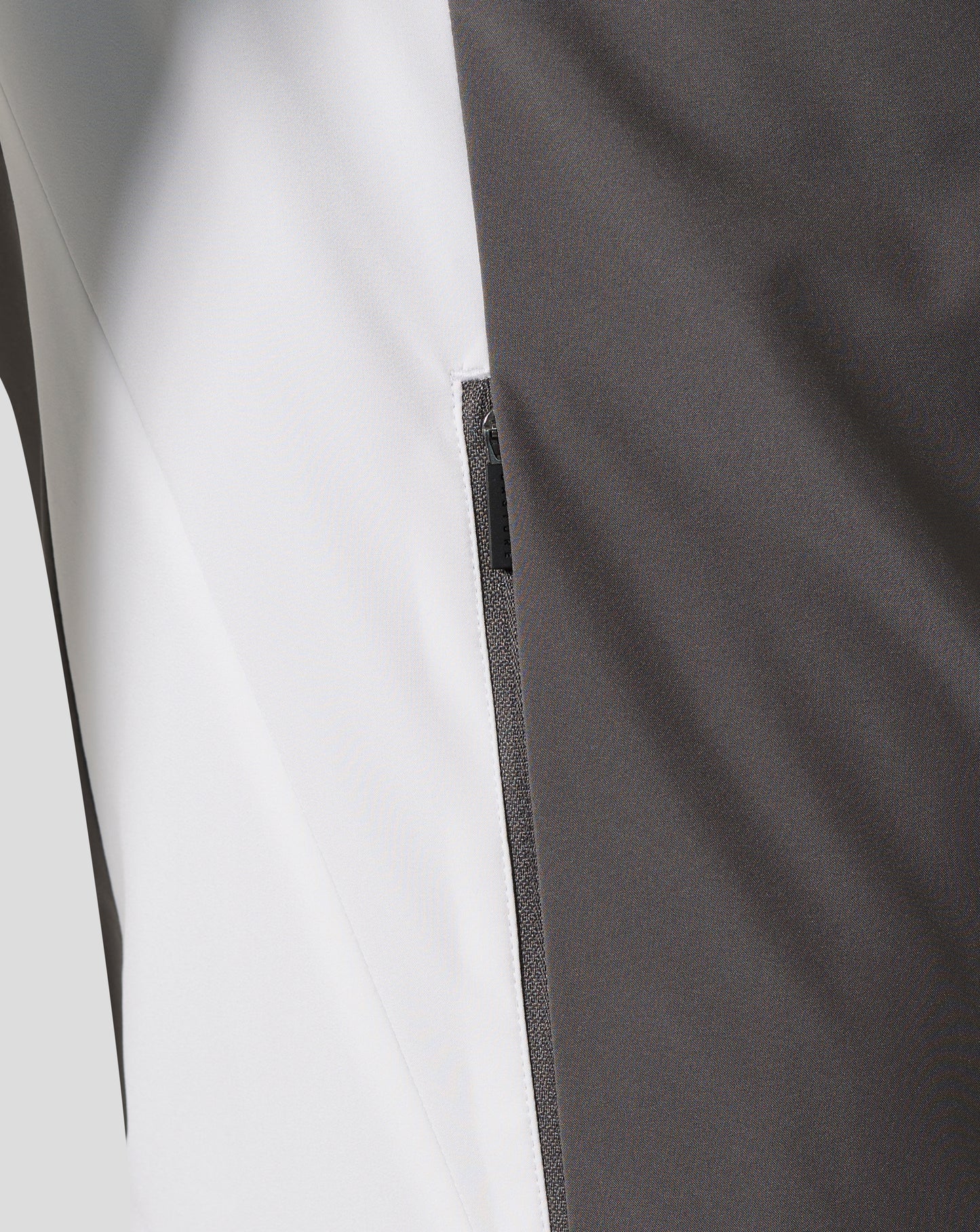 Close-up of white and charcoal fabric panels with a silver zipper on the Everton FC Thunderstorm packable hooded shower jacket