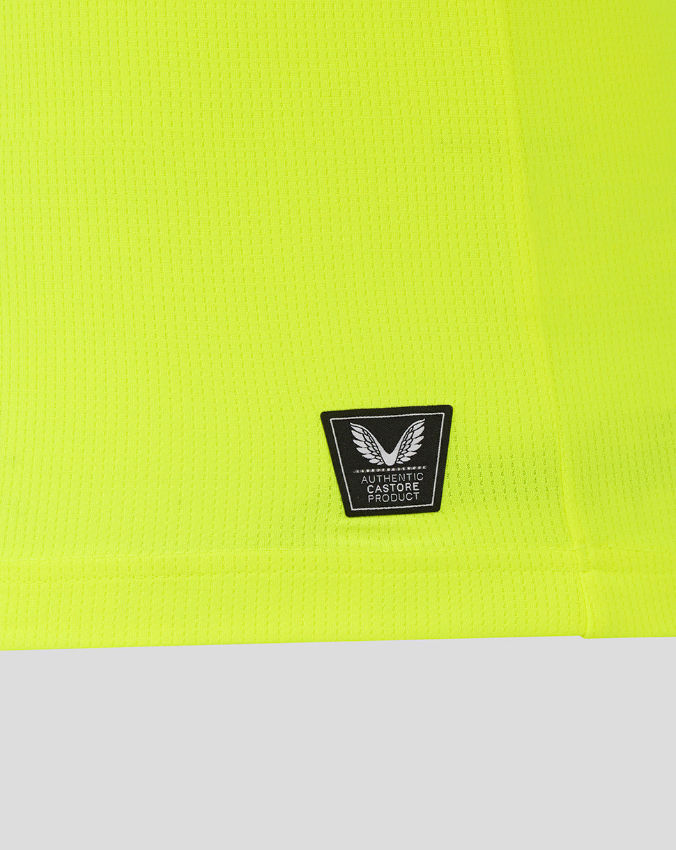 Neon yellow fabric close-up with authentic Castore product badge on the lower front of the Preston North End replica shirt.