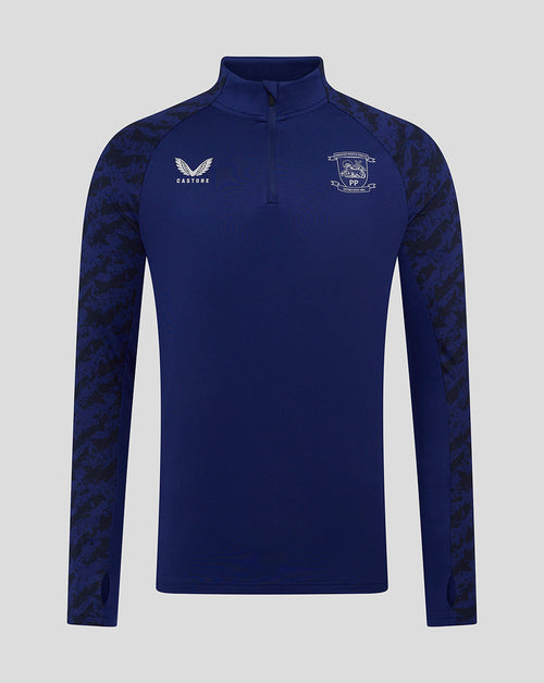 Front view of Preston Junior blue training midlayer with camo sleeves and Castore logo on the right chest.