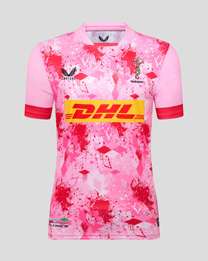 Front view of pink Harlequins away replica shirt with red splatter pattern and DHL sponsor across the chest; Harlequins crest and Castore logo visible.