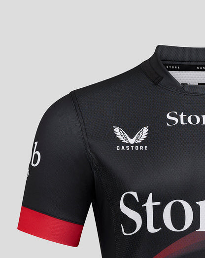 Front upper torso view of Saracens Pro Home Shirt displaying Castore logo and wing emblem on dark fabric with red sleeve cuff