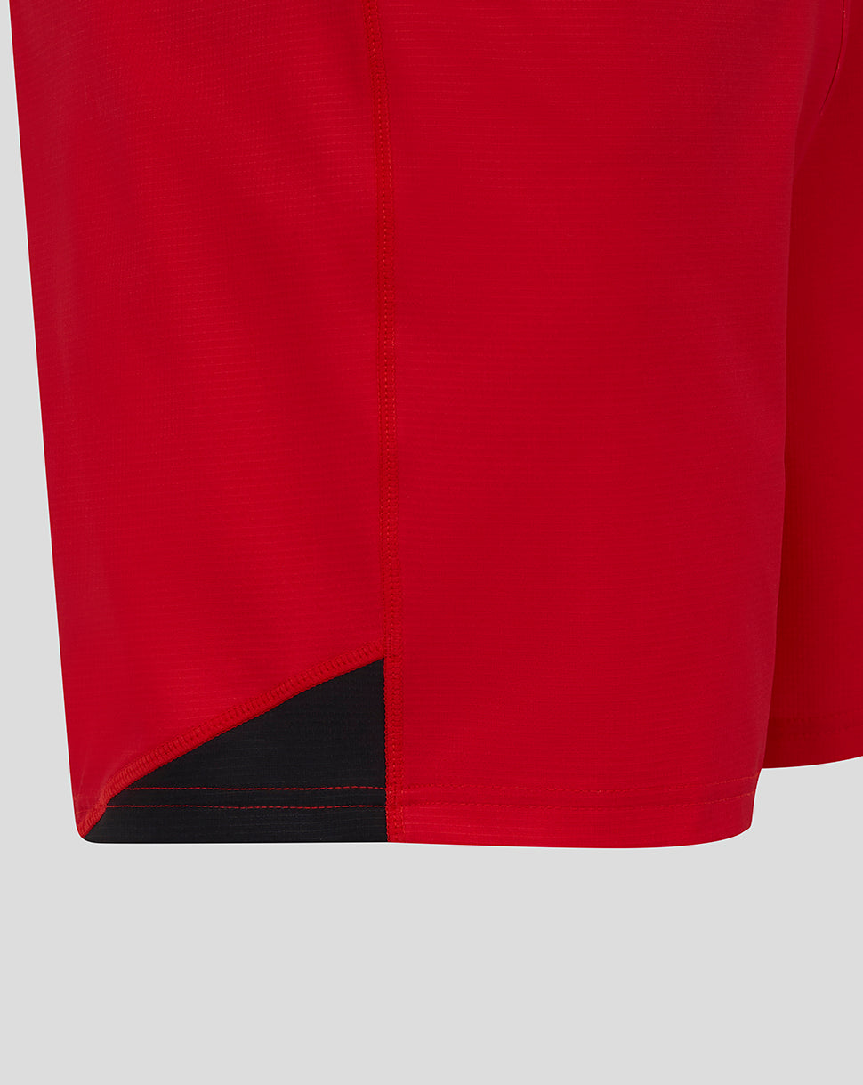 Close-up of red Saracens shorts showing the curved hem and black underlayer detail.