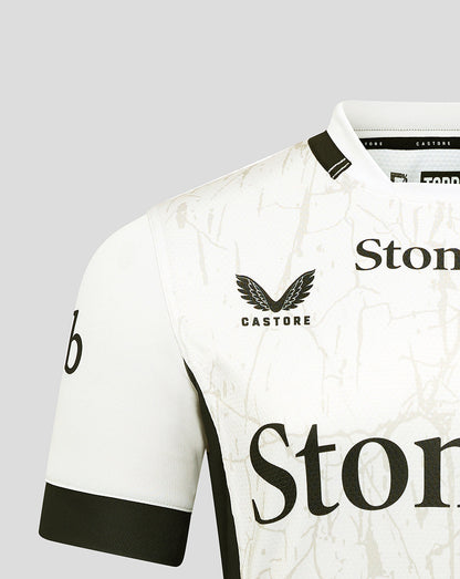 Saracens shirt close-up of chest with StoneX sponsor and Castore branding on marble pattern.