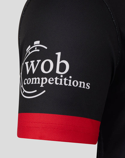 Close-up of a black Saracens replica shirt sleeve with the wob competitions logo and a red cuff.