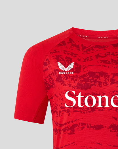 Close-up of chest on red Saracens matchday tee featuring crest and StoneX branding on textured fabric