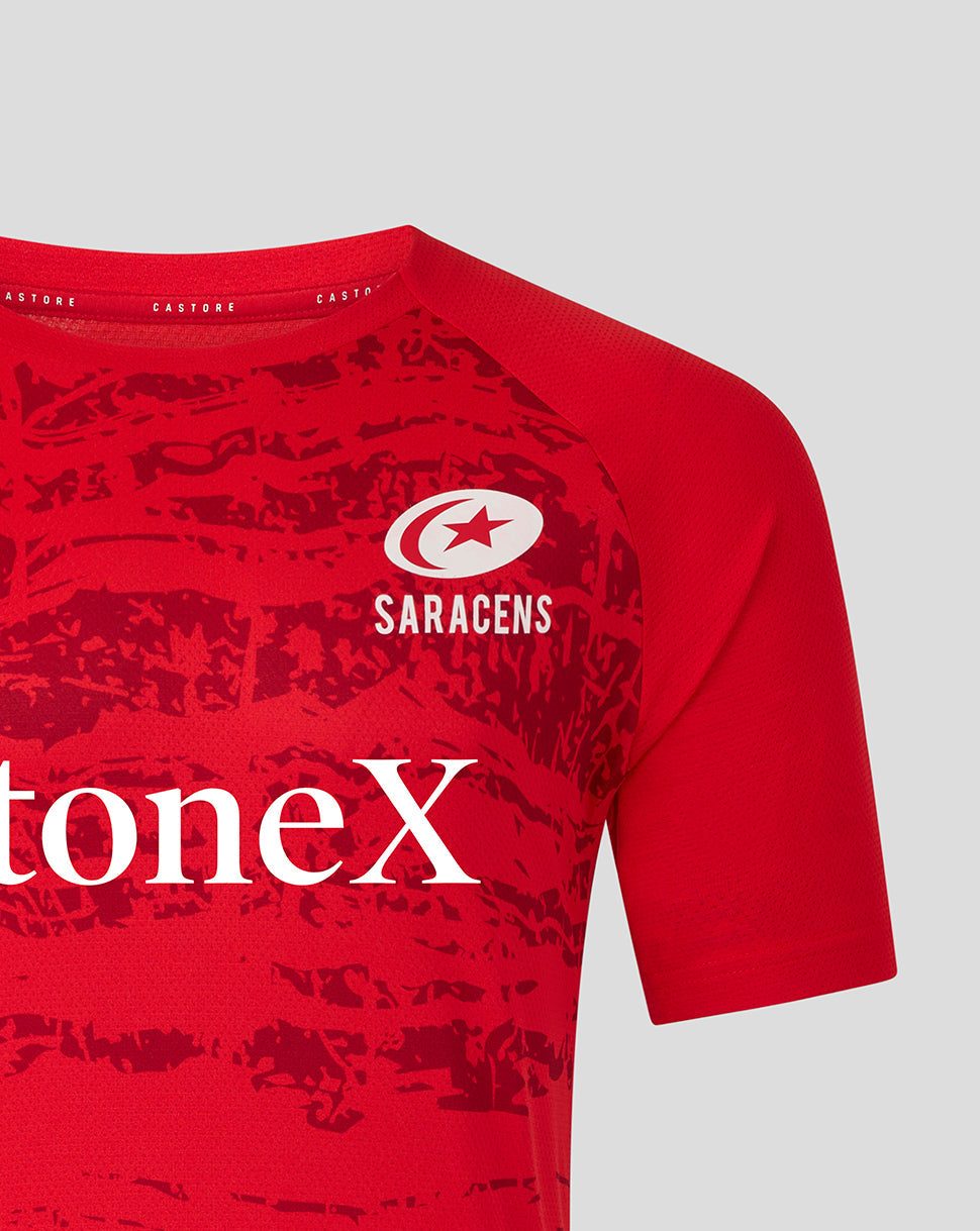 Detail view of the upper chest showing Saracens crest on red tee with a partial StoneX logo on the patterned fabric