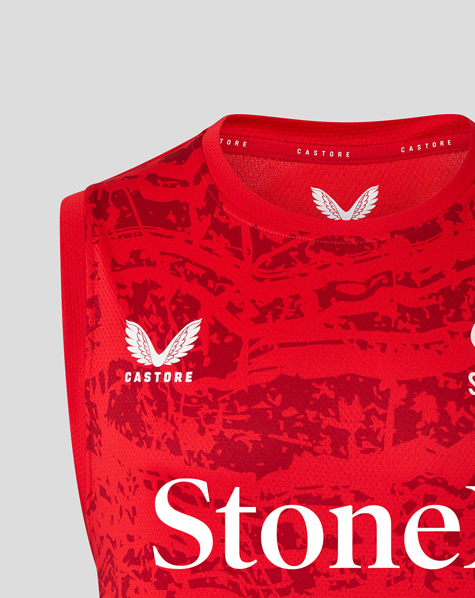 Close-up of red Saracens sleeveless tee neck area showing Castore branding and a white wing crest with StoneX text across the chest.