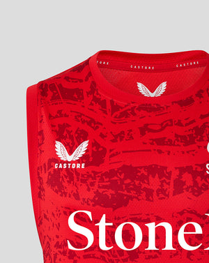 Close-up of red Saracens sleeveless tee neck area showing Castore branding and a white wing crest with StoneX text across the chest.