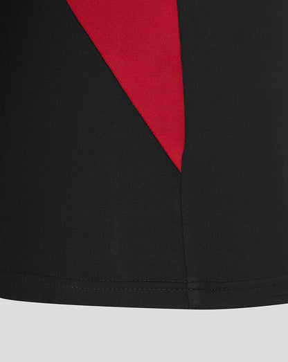Close-up detail of a black Saracens training top with a red angular panel.