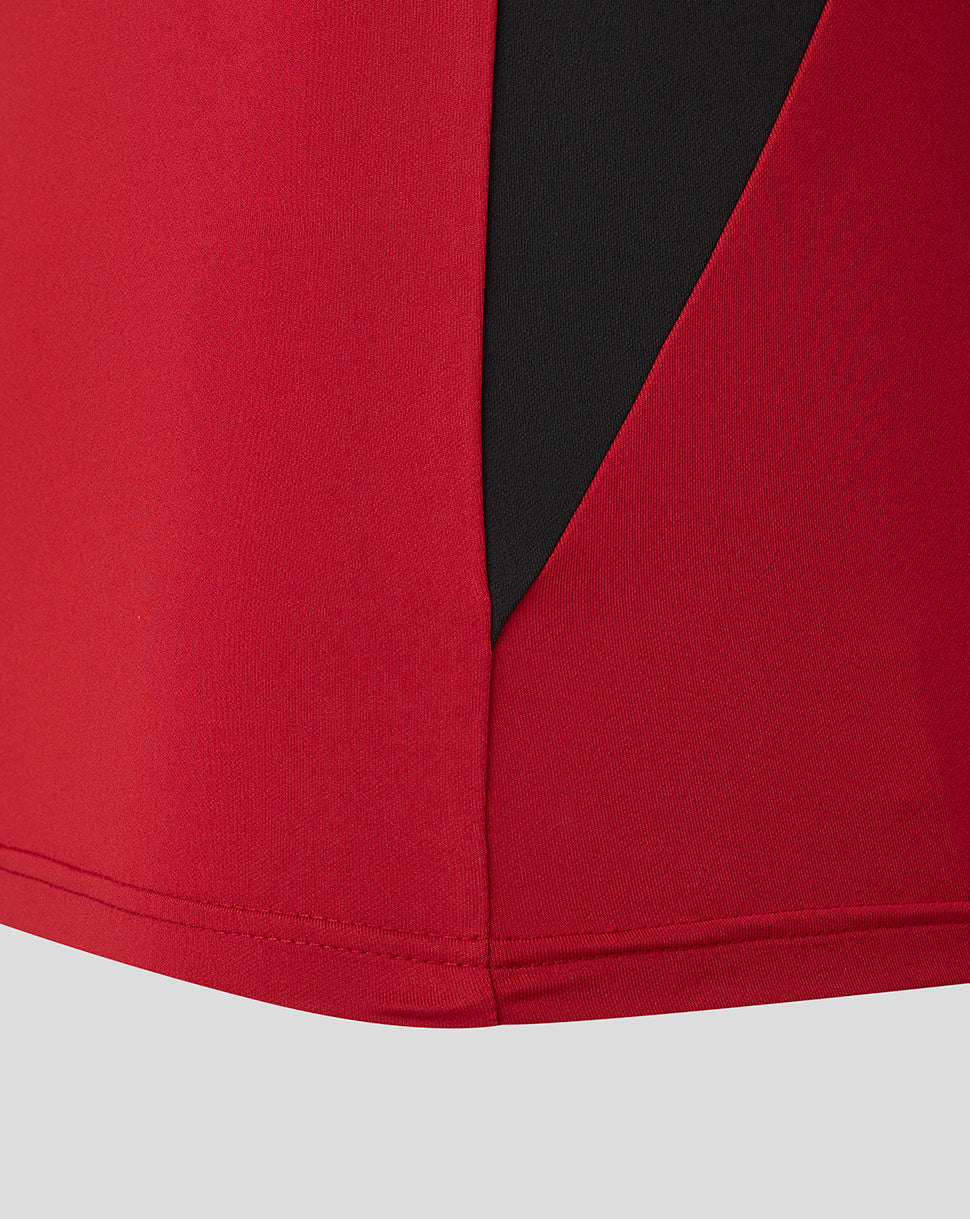 Close-up of red fabric and black zip panel on the Saracens training top.