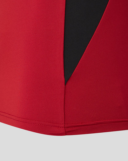 Close-up of red fabric and black zip panel on the Saracens training top.