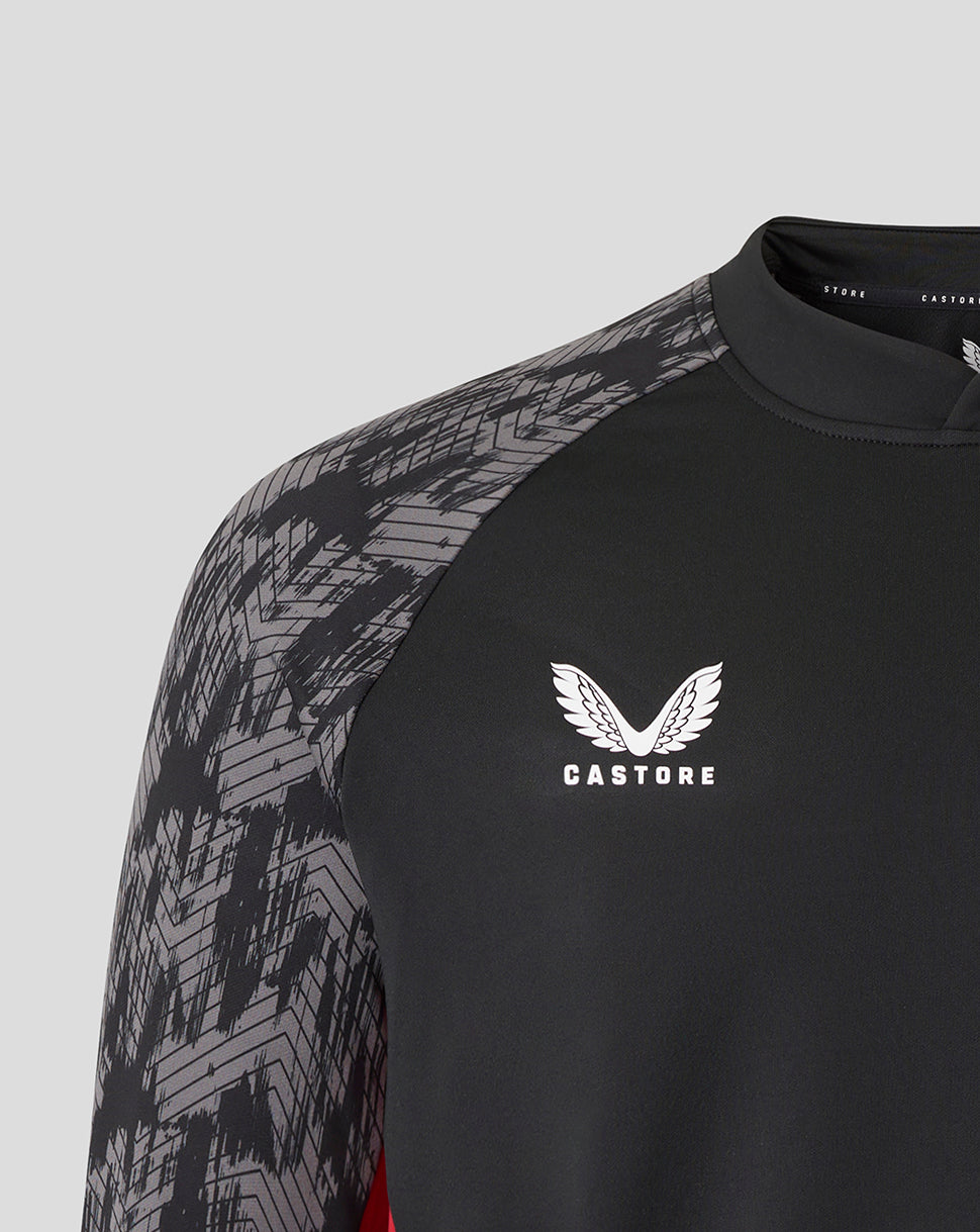 Close up of shoulder and chest showing the geometric patterned sleeve and Castore logo on a black Saracens top