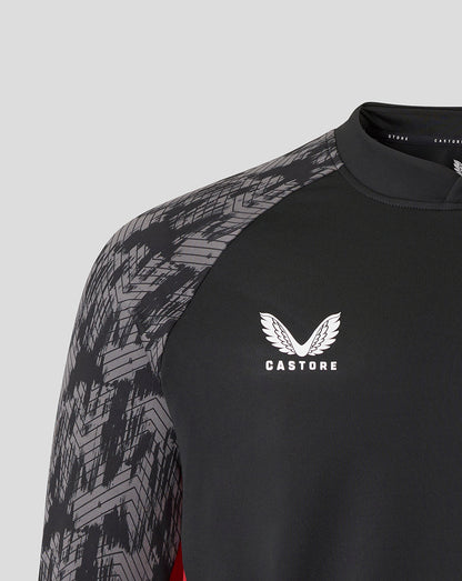 Close up of shoulder and chest showing the geometric patterned sleeve and Castore logo on a black Saracens top
