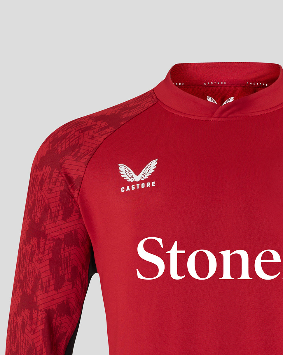 Close-up of red Saracens training top highlighting the chest crest and bold StoneX sponsor text across the torso.