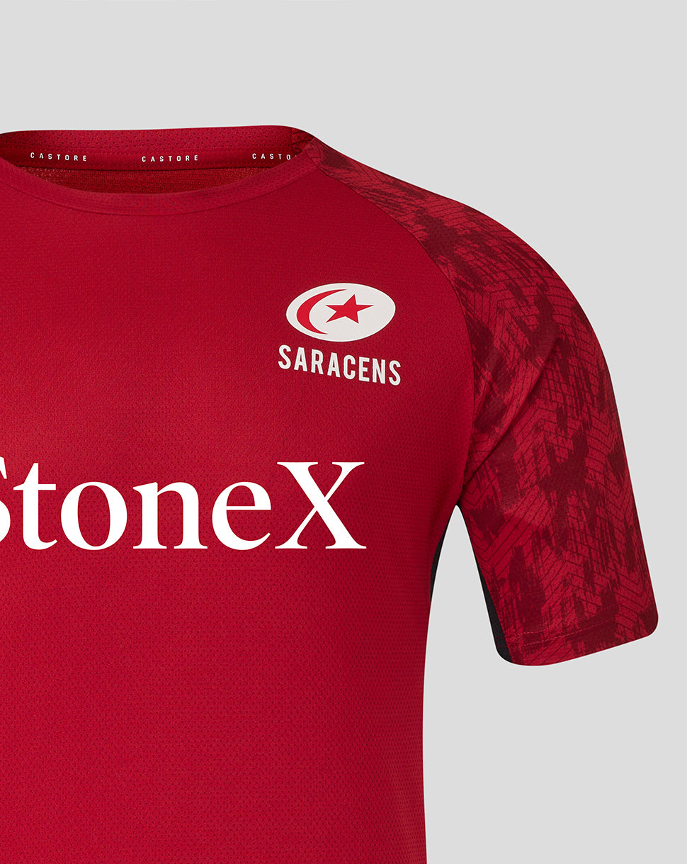 Close up of red Saracens training tee showing crest logo on chest and bold StoneX branding.