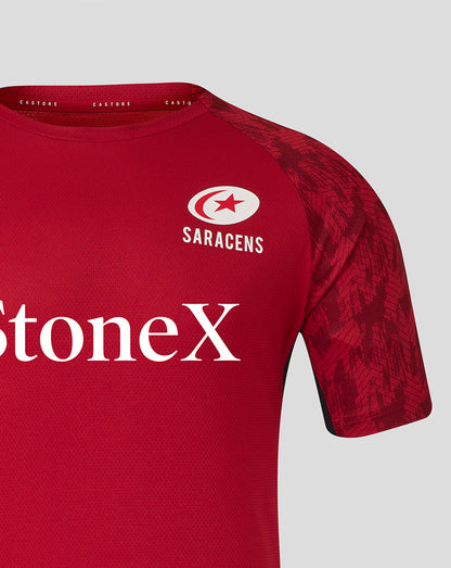 Close up of red Saracens training tee showing crest logo on chest and bold StoneX branding.