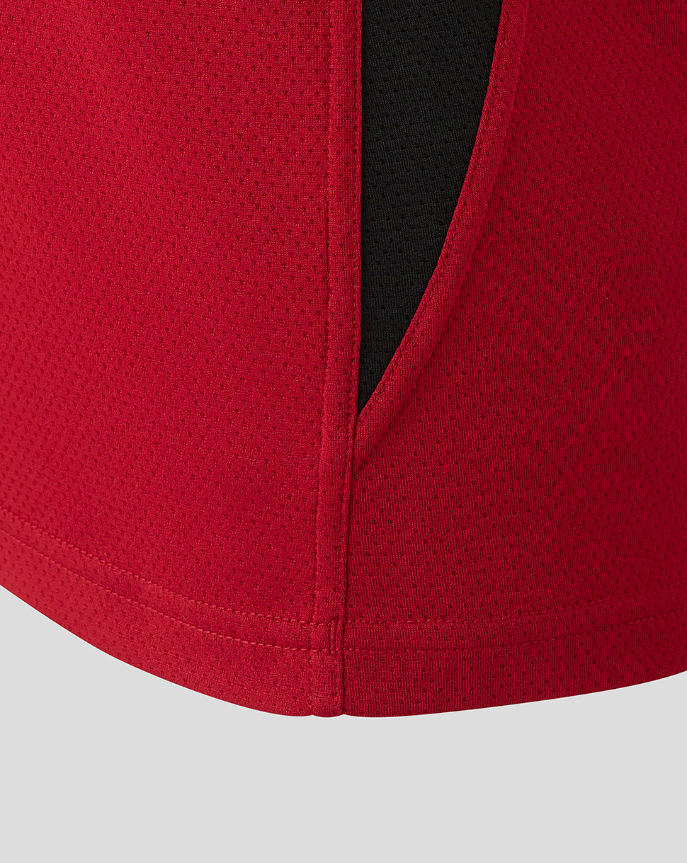 Close-up of the vest hem with stitching and a side vent on red fabric