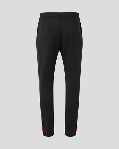 Back view of black training pants with red side stripes and tapered ankles.