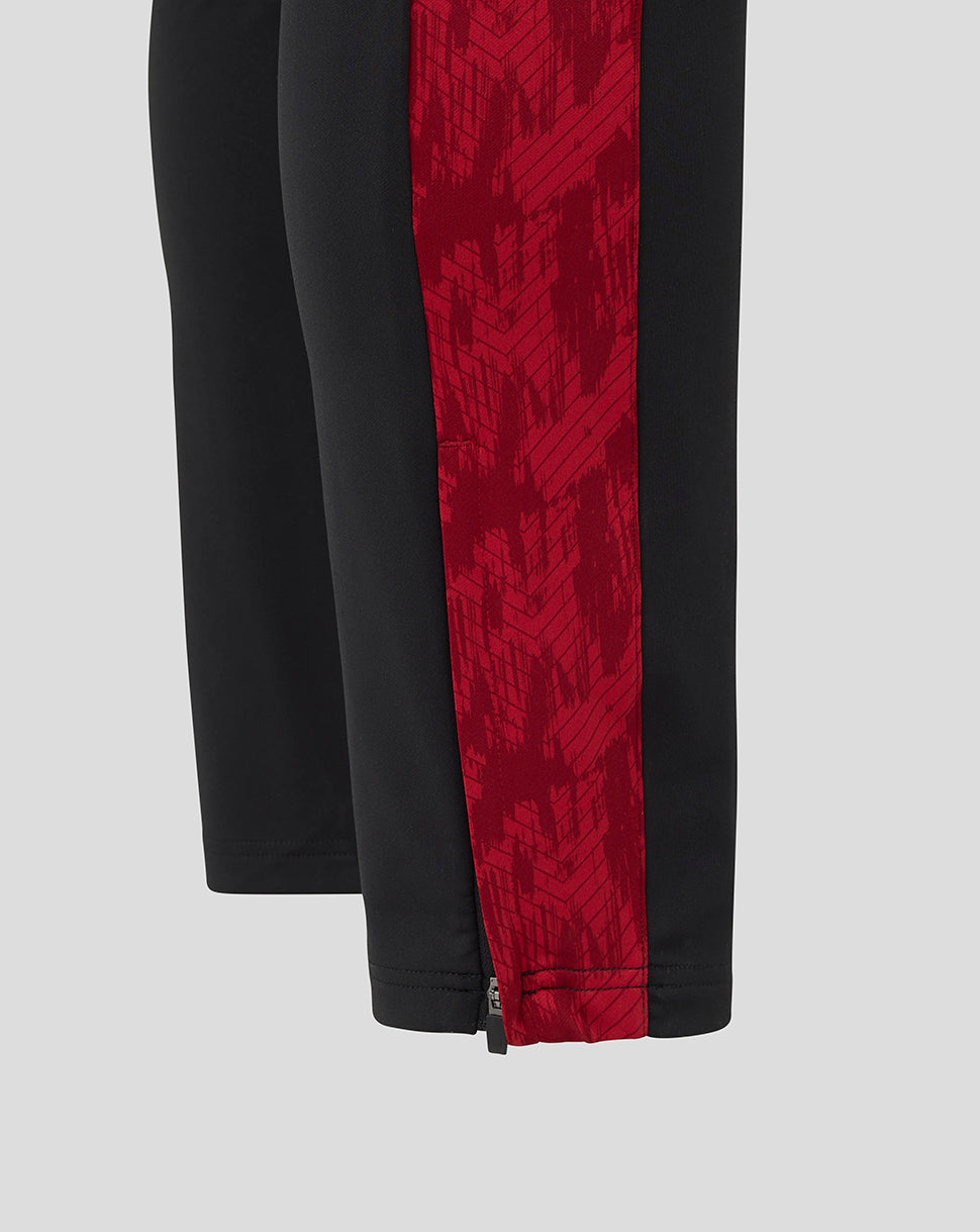Pant leg of Saracens training pants in black with a red patterned side stripe and a zip at the hem