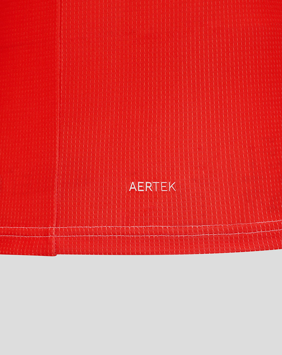 Close-up of red textured jersey fabric with AERTEK label near the hem
