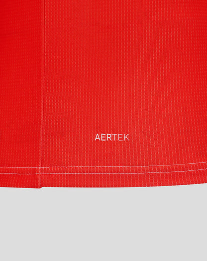 Close-up of red textured jersey fabric with AERTEK label near the hem