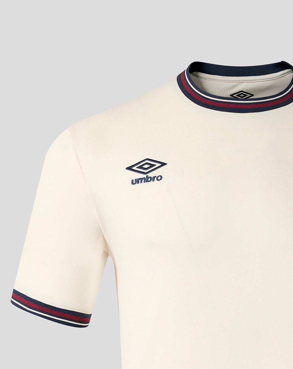 Close up of the front upper chest on the cream away shirt featuring the Umbro logo and a striped collar.
