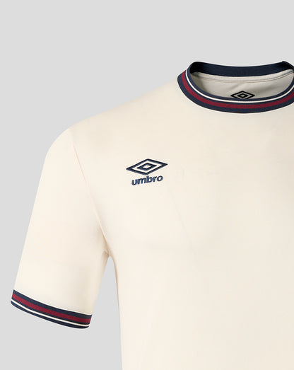 Close up of the front upper chest on the cream away shirt featuring the Umbro logo and a striped collar.