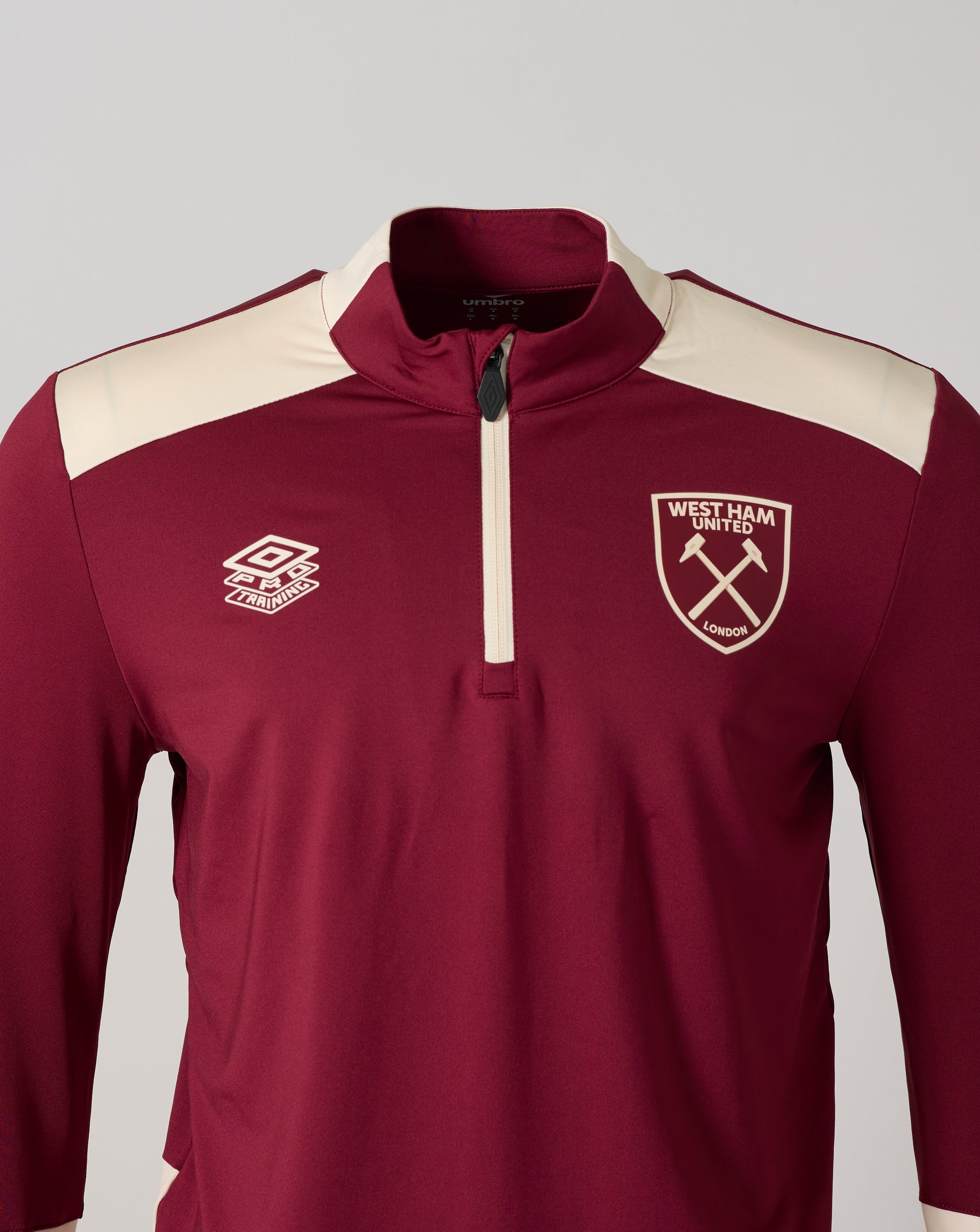 Close-up of burgundy West Ham training top showing collar zipper and left chest crest.