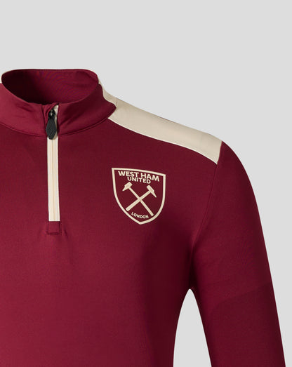 Close up of West Ham United training midlayer in rhododendron red with a beige shoulder stripe and front zipper