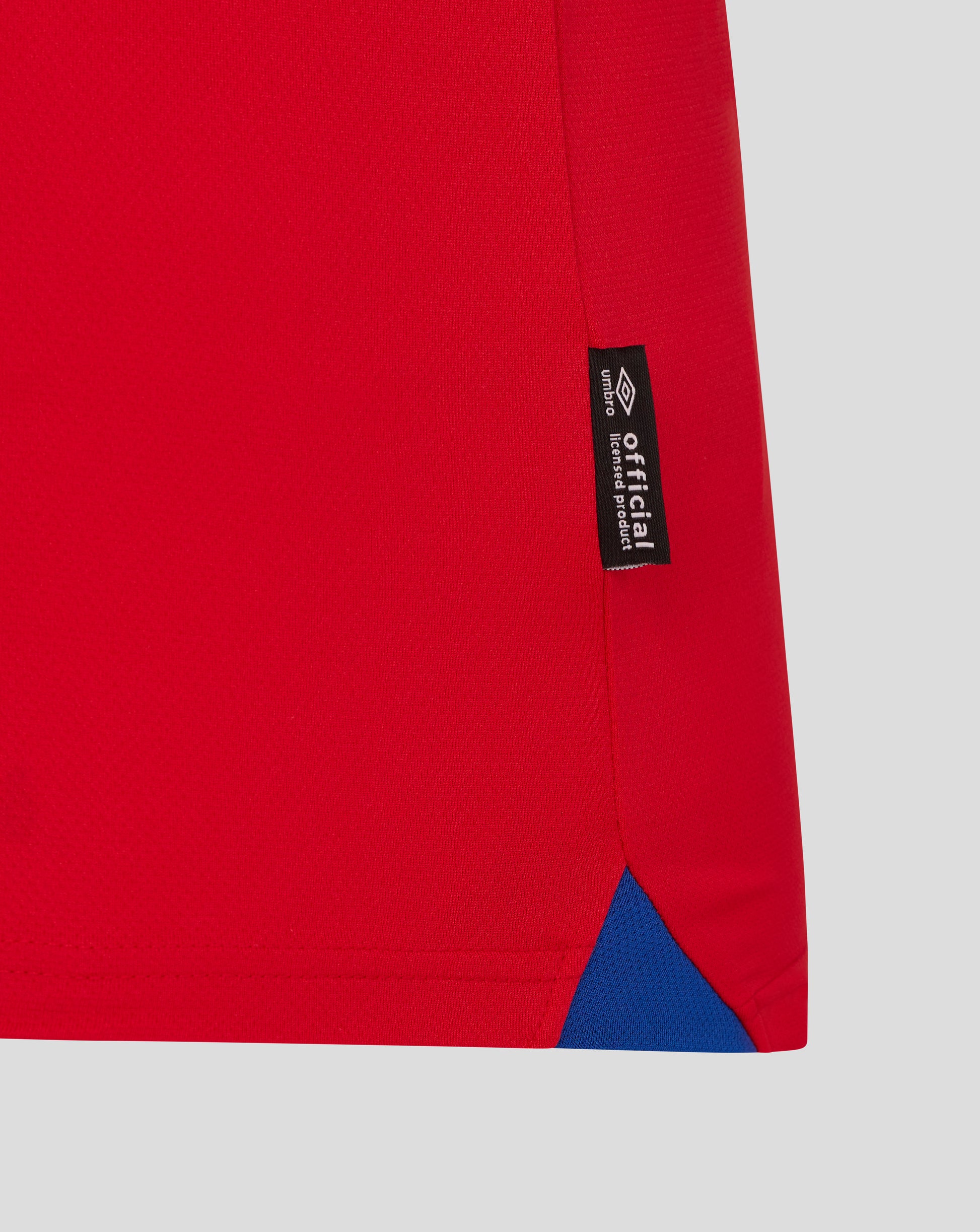 Red Ipswich Town away shirt hem with black tag reading official licensed product and Umbro logo