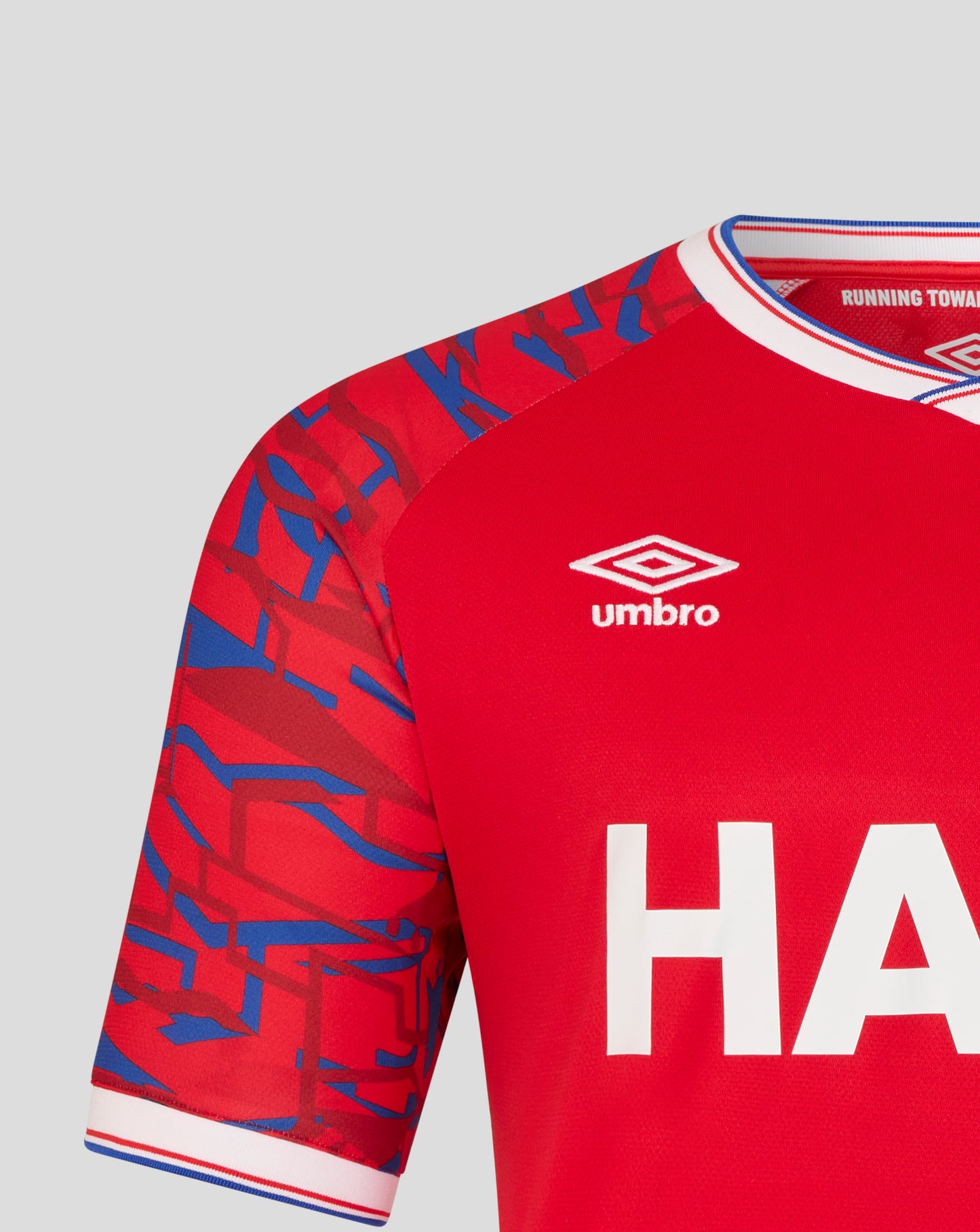 Ipswich Town away shirt sleeve in red with blue geometric pattern and white collar trim