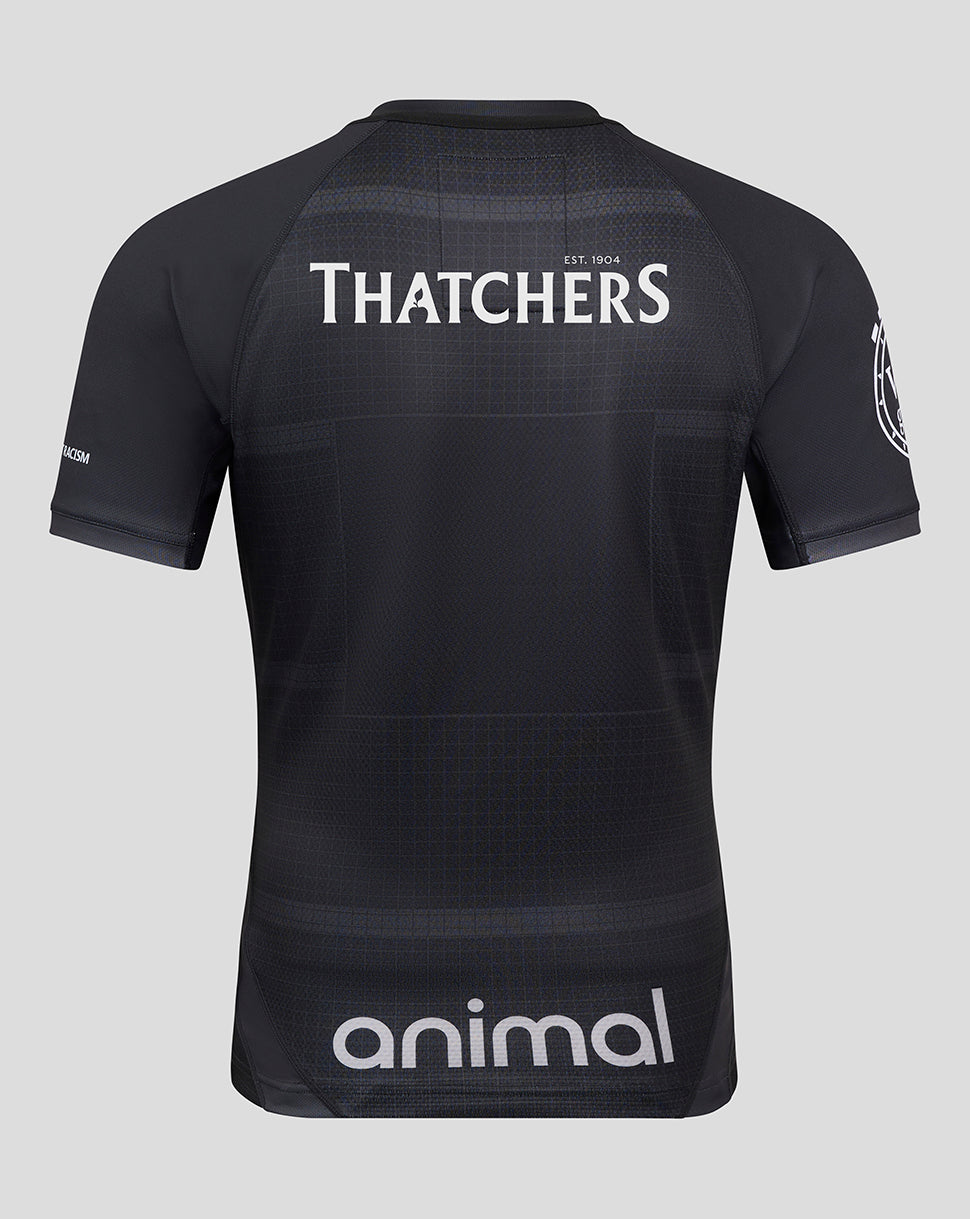 Back view of a dark patterned shirt with THATCHERS across the upper back and an animal sponsor at the lower back.